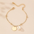 Close-up of gold shell bracelet with round charms and adjustable lobster clasp chain - Gold Yellow