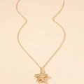 Detailed view of golden starfish pendant with intricate textured surface on a link chain - Gold Yellow