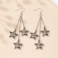 Macro detail of retro silver star tassel earrings with delicate long metal chains - Antique Silver