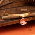 Macro-opname van gouden armband met emaille spookhanger en de afmetingen in detail - Bezem Geest Bedel