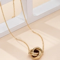 Elegant gold-tone twisted interlocked triple ring pendant necklace on a geometric display - Gold Yellow