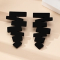 Detailed macro shot of matte black geometric jagged stud earrings with stylish shadows - Black