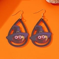 Dettaglio orecchini a zucca di Halloween con cappello viola su sfondo arancione - Stile Zucca con Cappello da Mago
