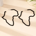 Macro-opname van minimalistische zwarte Afrika-kaart oorbellen op een beige achtergrond - Zwart