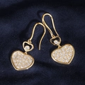 Macro detail of gold heart earrings with white cubic zirconia pavé on blue velvet - 18K Gold Heart Ear Hooks