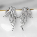 Close-up of silver tassel earrings with micro-set zircons on a white porcelain tray - Silver Winged Dangle