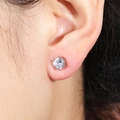 Classic silver four-prong round zircon stud earrings for women shown worn on ear - Stud Earrings / 6MM Silver