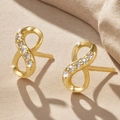 Goldene Infinity-Ohrstecker mit Zirkonia-Akzenten auf einem warmen Hintergrund - Gold