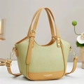 Borsa a mano in pelle verde e marrone con nappe e tracolla su una superficie bianca - Verde