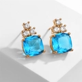 Macro-opname van geometrische hemelblauwe zirkoon oorbellen met gouden afwerking op wit - Wit + Meerblauw Verguld (EP5454)