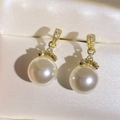 Detailed macro view of gold-plated curved earrings with white pearls and sparkling zircons - Large Round Pearl Rhinestone Style (EP6048-White Pearl Gold Plated)
