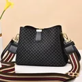 Detail of quilted leather bucket bag with striped wide shoulder strap and gold hardware - Grid/Black