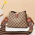 Detail of checkered bucket bag with colorful woven striped strap and gold hardware - Khaki Checkerboard/Earth Yellow