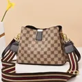 Close-up of bucket bag showing checkerboard floral pattern and striped woven shoulder strap - Khaki Checkerboard/Coffee