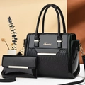 Detail of black patent leather handbag set featuring crocodile pattern and gold hardware - Black