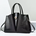 Dettaglio della borsa tote nera con pelle goffrata coccodrillo e fibbia dorata lucida - Nero