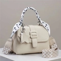Détail du sac à main crème en cuir litchi avec poignée foulard à pois et pendentif étoile - Blanc Cassé