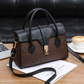 Contrast color monogram tote bag with gold lock on a rustic wooden desk with coffee - Black