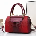 Burgunderfarbene Handtasche aus Krokodilleder mit goldenen Details und Logo - Weinrot