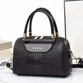 Elegante schwarze Eimertasche mit Echsenstruktur und goldener Hardware auf Marmor - Schwarz