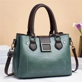 Detail of vintage contrast color handbag with silver metal buckle and textured leather finish - Green