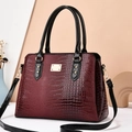 Elegant burgundy crocodile pattern handbag with gold hardware and black straps - Wine Red