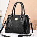 Elegant black faux lizard pattern handbag with glossy finish and gold metal accents - Black