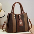 Detail of vintage striped woven handbag with leather handles and metallic rivet accents - Brown