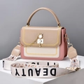 Contrast color crossbody bag with cat pearl lock and wide floral strap on a white pedestal - Khaki with Pink