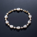 Elegantes Goldarmband mit birnenförmigen Zirkonia und Blumen-Elementen auf Schwarz - 18K Gold