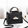 Elegante borsa in pelle nera con manico in metallo e dettagli intrecciati - Nero
