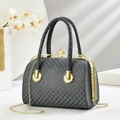 Bolso de noche negro con relieve, cadena dorada y cierre de perla sobre fondo de piedra - Negro