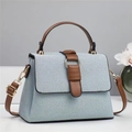 Dettaglio della borsa tote azzurra con tracolla marrone e anello metallico dorato - Blu