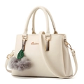 Chic cream leather handbag with golden logo and decorative pom-pom on white background - White