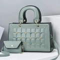 Close-up of sage green quilted tote bag featuring metallic studs and matching envelope pouch - Green