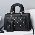 Detalle de bolso en cuero acolchado negro con tachuelas doradas y monedero a juego - Negro