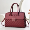 Detail of burgundy crocodile pattern handbag with elegant gold buckle and square texture - Burgundy