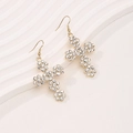Elegant gold cross earrings with sparkling flower crystals on a white textured background - Gold