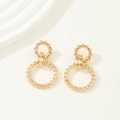 Close-up of golden rope twisted geometric earrings on an elegant textured background - Gold