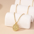 Vintage-Goldhalskette mit rundem Blumenrelief-Anhänger auf minimalistischem Ständer - Gold