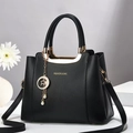 Elegante bolso de mano en cuero negro granulado con herrajes dorados y un colgante - Negro