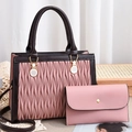 Detail of pink and brown contrast handbag set with wavy texture on a wooden tray - Pink