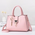 Rosafarbene minimalistische Tragetasche mit Quastenanhänger und Gurt auf weißem Grund - Rosa
