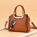 Brown woven texture tote bag with metallic handles and daisy charm on orange backdrop - Earthy Yellow