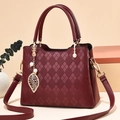 Quilted burgundy tote bag with pearl leaf charm and elegant gold-tone metal hardware - Burgundy