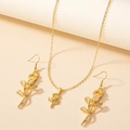 Elegante set di gioielli con collana e orecchini a rosa dorata da donna su sfondo caldo - Set Rosa in Oro