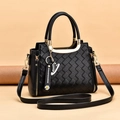 Black woven texture crossbody bag with gold metal handle and daisy charm detail - Black