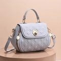 Light blue quilted shell-shaped handbag with golden clover lock and crossbody strap - Blue