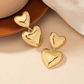 Bohemian double heart gold drop earrings with polished finish on warm knit background - Gold