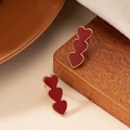 Detail showing the red enamel triple heart drop earrings with gold metallic edges - Burgundy